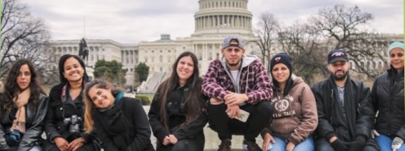 students sitting in front of U.S. Capitol