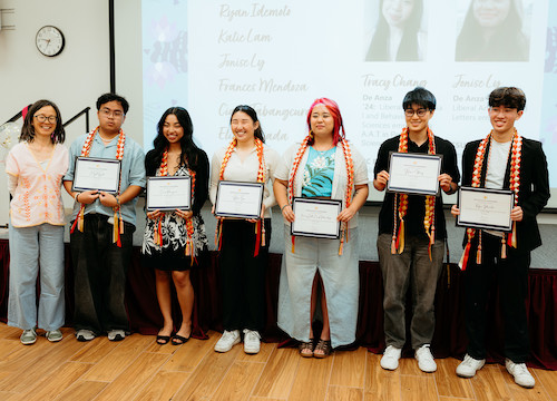 line of students with certificates and colored sashes