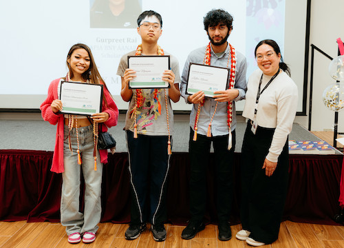 three students with certificates and counselor