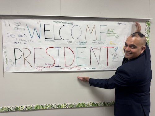 President Torres with banner that says "Welcome President"