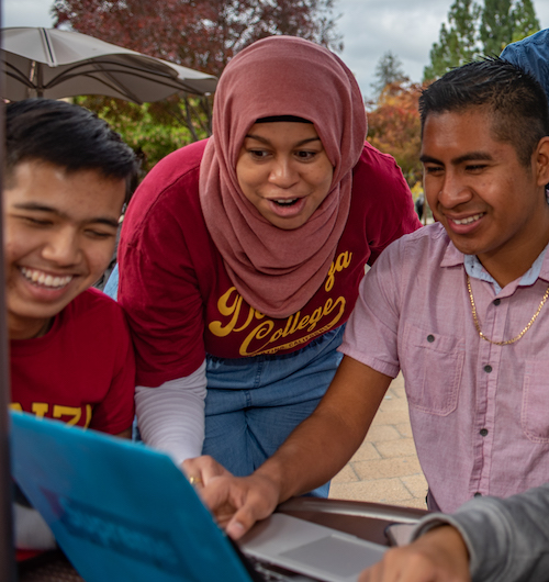 students looking at laptop with excitement