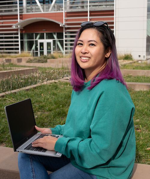 student outside with laptop