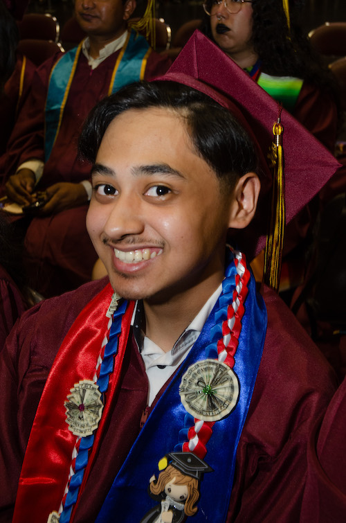 smniling young man with grad cap and sashes