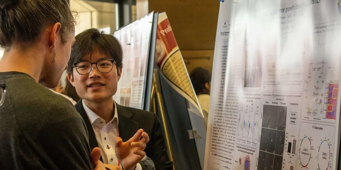 man talking at poster board